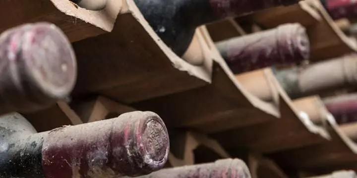italy-sicily-old-red-wine-bottles-aging-in-a-wine-cellar