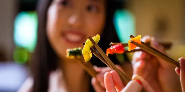 Att para mat och vin i Asien 12 asiatisk flicka äter med innar