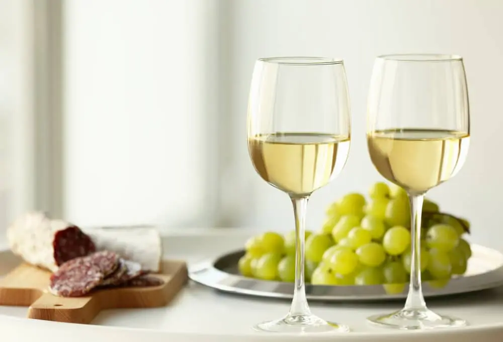 glasses-with-white-wine-and-grape-on-a-table